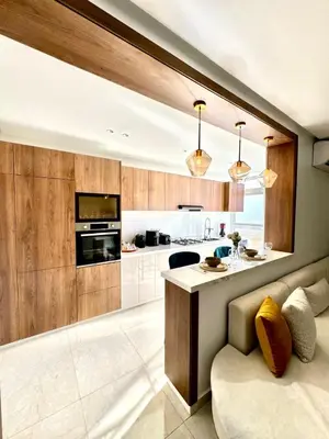 a kitchen with wooden cabinets and a counter top at La casa famille in Oulad Akkou