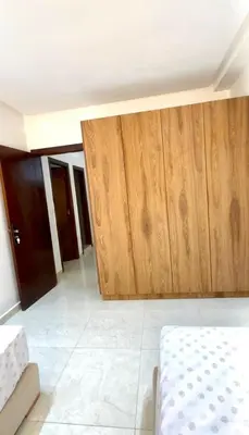 a room with a bed and wooden doors at La casa famille in Oulad Akkou