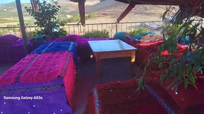 a room with two beds and a table with a view at Gîte Forest Tagroumet traditionel in Ifrane