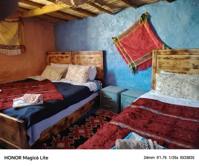 two beds in a room with blue walls at Gîte Forest Tagroumet traditionel in Ifrane