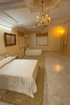 a bedroom with two beds and a chandelier at Appartement Pam Pam in Fès