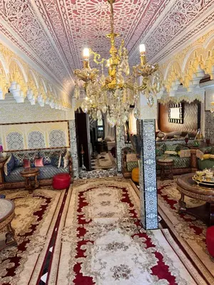 a large living room with a chandelier and a large room at Villat Riad, fête style marocain in Oulad Akkou