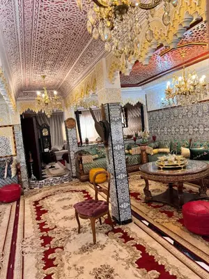 a large living room with a chandelier and a table at Villat Riad, fête style marocain in Oulad Akkou