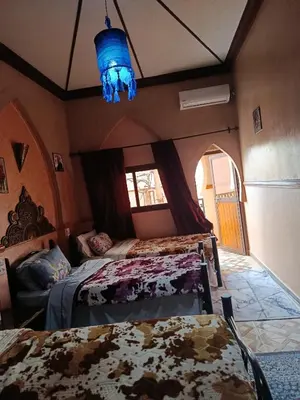 a bedroom with two beds and a blue light at Africa Hollywood in Aït Ben Haddou