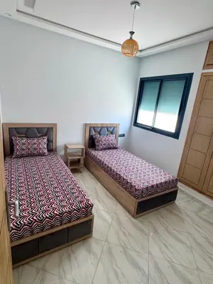 two beds sitting next to each other in a room at Luxurious apartment in Oud Fes golf city in Fès