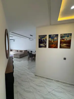 a room with posters on the wall and a table at Luxurious apartment in Oud Fes golf city in Fès