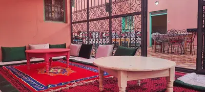 a room with a table and a table and chairs at Chambre partagée Hostel DAIFLAH