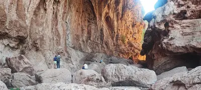 a person standing on rocks in a canyon at Chambre partagée Hostel DAIFLAH