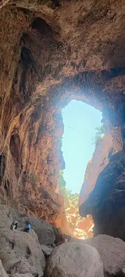 a large cave with a large body of water at Chambre partagée Hostel DAIFLAH