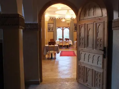 an open door to a dining room with tables at Palm Dades in Boumalne
