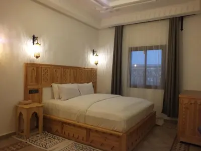a bedroom with a large bed and a window at Palm Dades in Boumalne