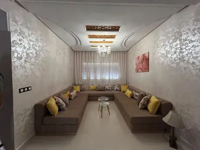 a living room with a large couch and yellow pillows at Luxurious apartment at a low price in Meknès