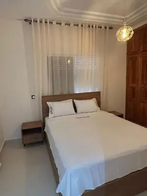 a bedroom with a large white bed with a window at Luxurious apartment at a low price in Meknès