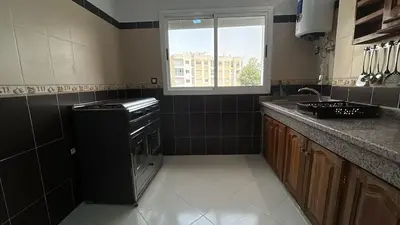 a kitchen with a stove and a sink and a window at Luxurious apartment at a low price in Meknès