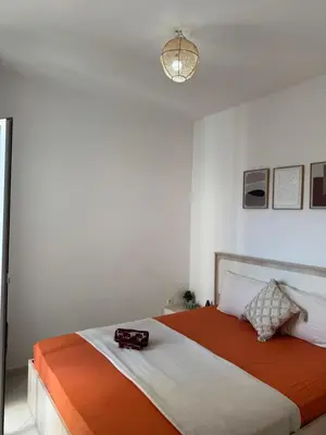 a bedroom with a bed with an orange and white blanket at Fès comfort stay in Fès