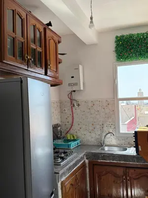 a kitchen with a refrigerator and a sink and a window at Fès comfort stay in Fès