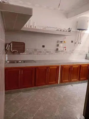 a kitchen with wooden cabinets and a white counter top at Appartement familial, plein centre d'Azilal in Azilal