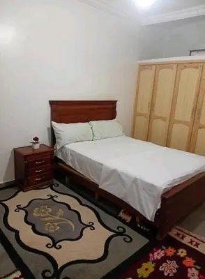 a bedroom with a bed and a nightstand next to a bed sidx sidx sidx at Appartement familial, plein centre d'Azilal in Azilal