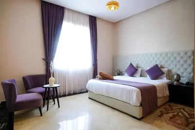 a bedroom with a bed and a chair and a window at Palais Dar Souhir in Sidi Bouzguia
