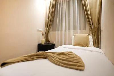 a bed with a blanket on it in front of a window at Palais Dar Souhir in Sidi Bouzguia