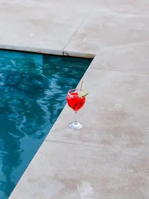 a drink in a glass next to a swimming pool at Palais Dar Souhir in Sidi Bouzguia