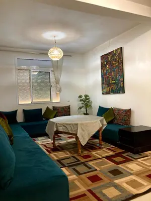 a living room with a blue couch and a table at Chill unique apartment in Ifrane in Ifrane