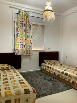 a bedroom with two beds and a window with a curtain at Chill unique apartment in Ifrane in Ifrane