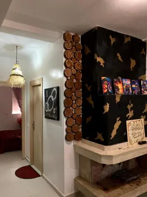 a fireplace in a living room with a black wall at Chill unique apartment in Ifrane in Ifrane