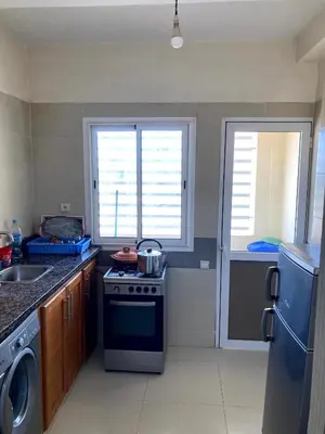 a kitchen with a stove and a sink and two windows at Chill unique apartment in Ifrane in Ifrane