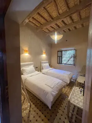 a bedroom with two beds and a window at Skoura Ranch Palm Grove in Ouarzazate