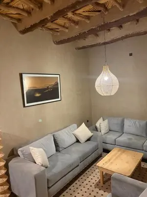 a living room with a couch and a table at Skoura Ranch Palm Grove in Ouarzazate