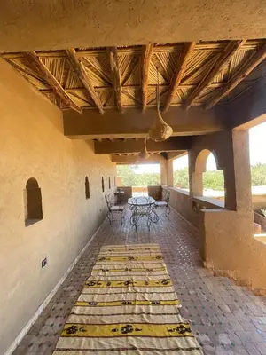 a patio with tables and chairs in a building at Skoura Ranch Palm Grove in Ouarzazate