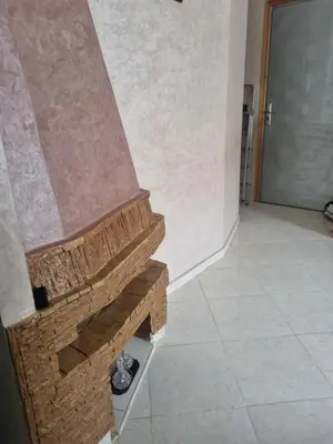 a stone fireplace in a room with a tile floor at Vip apartment in Fès