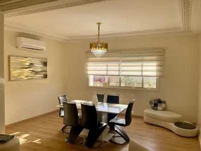 a dining room with a table and chairs and a chandelier at You'll be comfortable there! in Fès