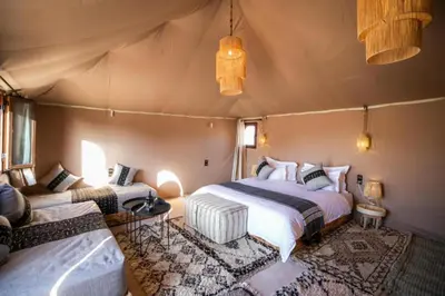 a bedroom with two beds in a tent at Starry Luxury Camp in Merzouga
