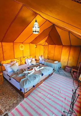 a bedroom with two beds in a tent at Starry Luxury Camp in Merzouga