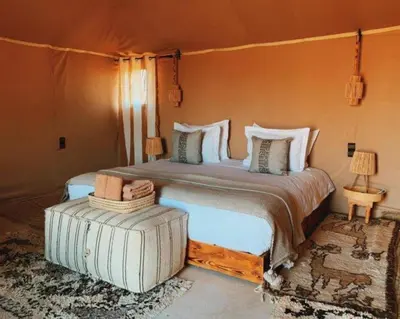 a bedroom with a large bed in a room at Starry Luxury Camp in Merzouga