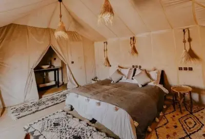 a bedroom with a bed in a tent at Starry Luxury Camp in Merzouga