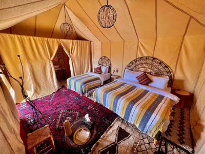 a bedroom with two beds in a tent at Starry Luxury Camp in Merzouga