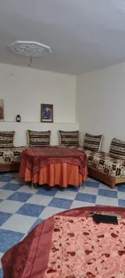 a room with two beds and a rug on the floor at Gite El Qalaa - مأوى القلعة in Taza