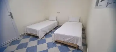 a room with two beds and a checkered floor at Gite El Qalaa - مأوى القلعة in Taza
