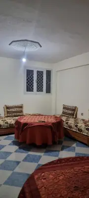 a room with a bed and two benches in it at Gite El Qalaa - مأوى القلعة in Taza