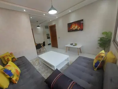 a living room with a couch and a table at Appartement centre ville in Oulad Akkou