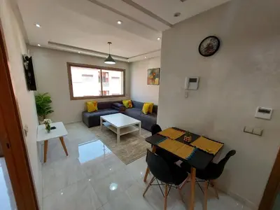 a living room with a couch and a table at Appartement centre ville in Oulad Akkou