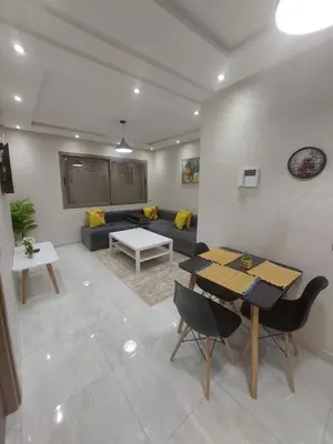 a living room with a table and a couch at Appartement centre ville in Oulad Akkou