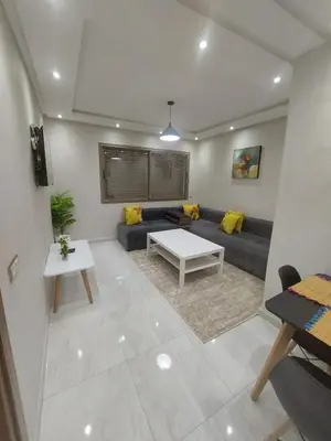 a living room with a couch and a table at Appartement centre ville in Oulad Akkou
