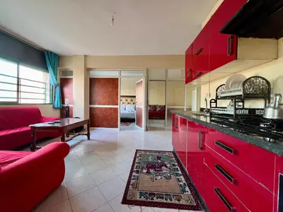 a kitchen with red cabinets and a red couch at Fes City Luxury Suites - Apartments & Studio in Fès