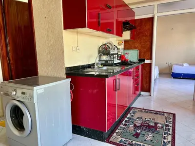 a kitchen with red cabinets and a washing machine at Fes City Luxury Suites - Apartments & Studio in Fès