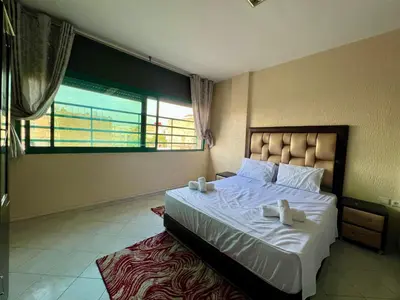 a bedroom with a large bed and a large window at Fes City Luxury Suites - Apartments & Studio in Fès