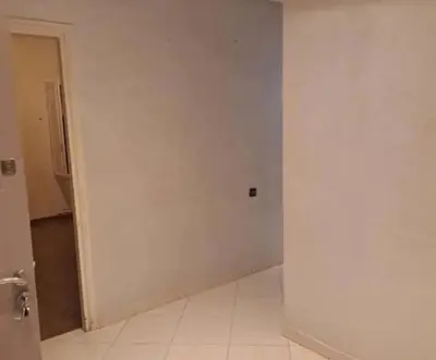 an empty room with a white wall and a door at Abdeslam in Kasba Tadla